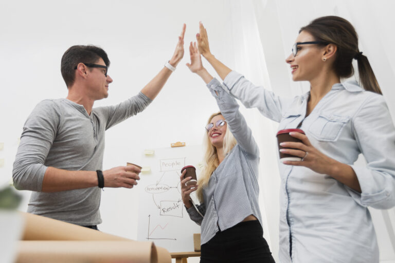 Joyful business partners celebrating with raised hands.